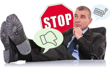 Hombre de traje y corbata con la mano en el mentón frente a un signo rojo de STOP.
