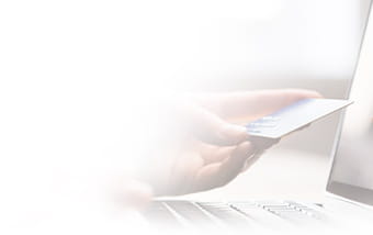 Un usuario utilizando una tarjeta de crédito frente a un portátil.